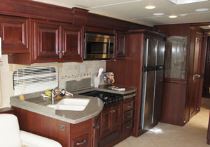 The galley in the Astoria motorhome features cherry cabinets topped with Staron solid-surface countertops.