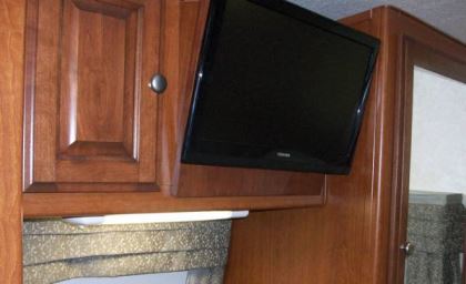 The rear bedroom is outfitted with a 15-inch LCD television mounted to an overhead cabinet.