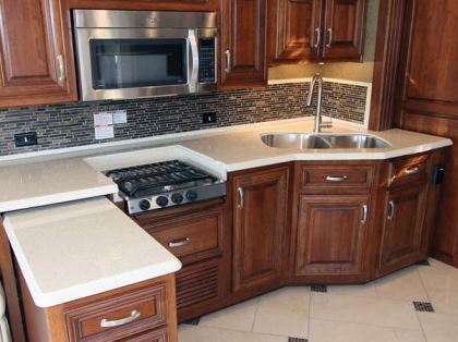 Galley prep is augmented by a stainless-steel dual-basin sink, a gas cooktop, a microwave-convection oven, and a slide-out workstation.