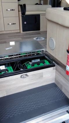 The motorhome's house batteries are placed inside the entry step for easy access.