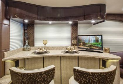 The Millennium review coach is graced with an elegant dining area for two, which faces the street-side window and includes a Mac mini computer monitor that raises up out of the granite countertop.