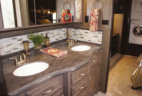 The Berkshire XLT’s stylish bathroom features a polished solid-surface countertop with a coordinating backsplash, double under-mount sinks, and mirrored medicine cabinets.