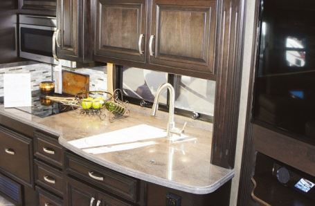 Galley features include hardwood cherry cabinetry, polished solid-surface countertops, and a double sink with a high-rise faucet and covers.