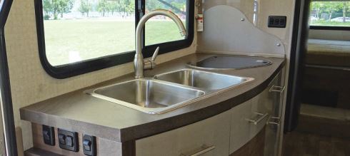 On the curb side of the 24G, the kitchen area incorporates a double-basin galley sink and a overed, two-burner cooktop.