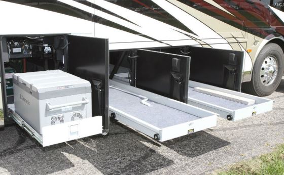 Power slide-out trays in the basement area of the King A ire, with access from either side of the coach, add convenience to storage space and provide access to the Dometic freezer that resides there.