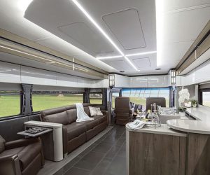 High-gloss laminate surfaces, stainless-steel trim, and LED lighting behind sleek ceiling panels give the Winnebago Horizon a contemporary feel.