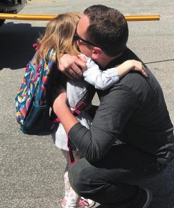 Lyla Smith, daughter of executive director Chris Smith, gets a big hug from dad on her first day of kindergarten.