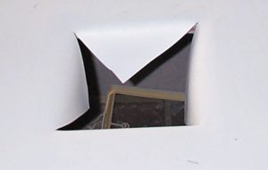 Cut an “X” from corner to corner of each roof cutout, fold the cut flaps down into the cutout, and staple them to the roof framing.