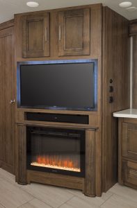 A fireplace and LED TV are on an angled wall. 