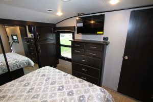 A 32-inch LED TV hangs opposite the king-size bed, in the Jayco Eagle, accompanied by plentiful bedroom storage.