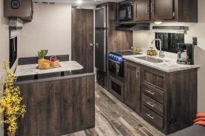 Features of K.Z.’s Sportsmen SE include residential-grade vinyl flooring, a 10-cubic-foot 12-volt refrigerator, and a drop-in cooktop with a glass cover.  