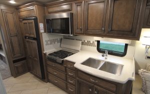 The galley in the Bay Star 3226 includes polished solid-surface countertops; a three-burner, recessed gas cooktop; and a double-basin stainless-steel sink.