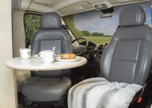 The cockpit seats in the Pleasure-Way Lexor FL, upholstered in Ultraleather fabric, swivel rearward to face the cantilevered table when it is secured to a wall bracket. 