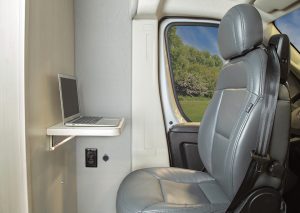 A workstation with power outlets and a USB charging port flips up behind the driver’s chair in the Pleasure-Way Lexor FL motorhome.