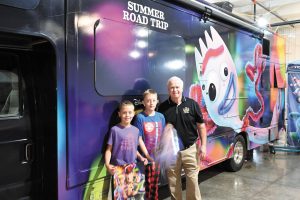 Dylan (left) and Jackson, grandsons of FMCA national president Jon Walker, checked out the Toy Story 4-themed RV with Darryl Searer, RV/MH Hall of Fame president.