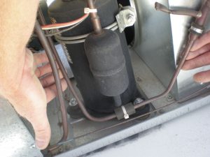 After removing the exterior shroud, inspect refrigerant tubing lines for cracks or leaks.