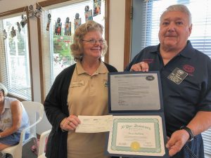 Don Schleuse, FMCA national vice president, Northwest Area, presents an anniversary certificate and check to chapter president Martie Martin.
