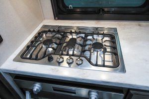 The stainless-steel three-burner gas cooktop is part of the Chef’s Galley appliance package, which also includes a stainless-steel gas oven.
