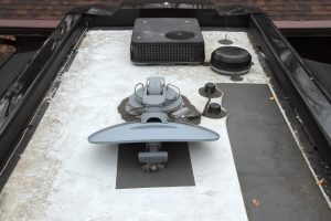 An air conditioner, an off-air antenna, and a satellite dish filled the front portion of the author’s motorhome roof, prompting him to find another area for installation.