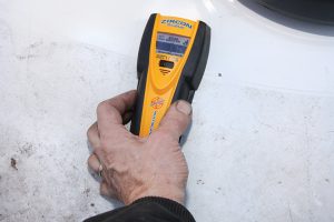 A stud finder was used to locate a roof joist so the unit could be secured to it.