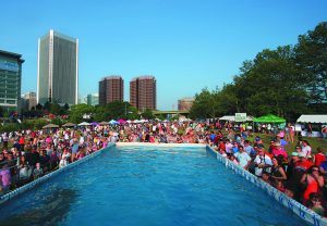 Spectators gather around a pool during an Ultimate Air Dogs event.
