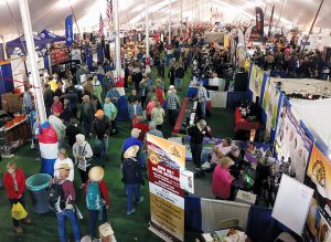 Shoppers check out RV-related merchandise under a giant tent.