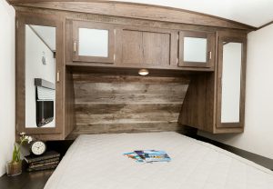 A rustic reclaimed-wood wall accents the head of the master bed.