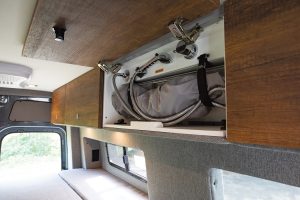 Storyteller Overland's HALO inside shower stows in an overhead cabinet and is easily retrieved and set up when needed.