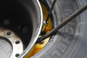 With a tire iron holding the tire bead away from the rim, the Rettroband tensioner is tightened using a 3/8-inch drive ratchet, socket, and extension.