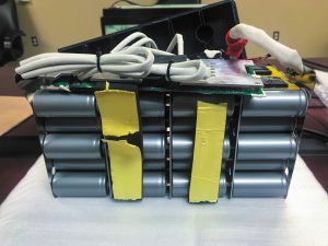 A lithium-ion battery with cylindrical cells bolted together. Output leads are soldered.