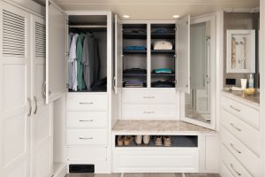 A complex of floor-to-ceiling wardrobes, closets, drawers, and a shoe cubby fills the rear wall.