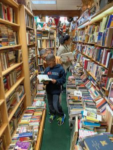 Tia, Justin, and Jayson Sims peruse titles at a bookstore.
