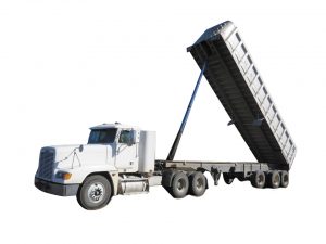 Truck drivers return excess dirt from each load to the same farm.