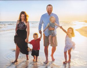The Smith family has grown over the past decade. Chris and his wife, Jill, take a stroll on a Florida beach with their children: Lyla (far right), who is now age 8; Miles (left), age 4; and Brody (in Chris’ arms), age 3.
