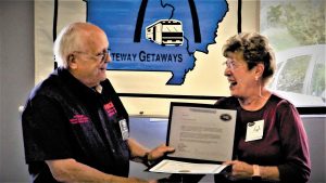 Joe Wright, FMCA national vice president, South Central Area, presents Gateway Getaways president Guen Douglas with a certificate recognizing the chapter's 25th anniversary.