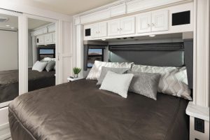 The bedroom contains a king-size bed. Mirrored wardrobe storage extends across the rear wall.
