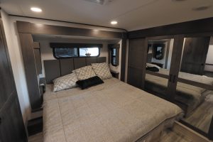 The bedroom includes a standard king-size bed and a walk-in wardrobe with mirrored doors.