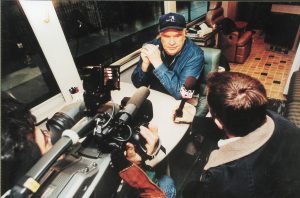 Reporters interview John aboard bus number three.