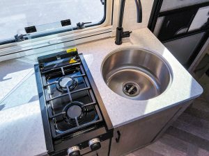 The galley has a two-burner cooktop and stainless-steel sink.