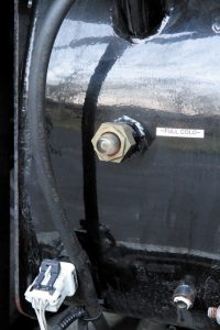 To check the coolant level, use the sight glass in the coolant surge tank.