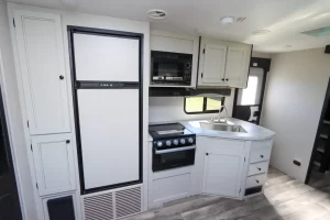 The Range Lite 252RB's galley has a microwave, conventional oven, three-burner range, propane/electric refrigerator, and nearby pantry.