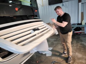 After removing the old film, installer Boris Yegorov (above) applied new pieces of Diamond Shield onto the front cap of the Britz’s motorhome. It now looks brand-new.