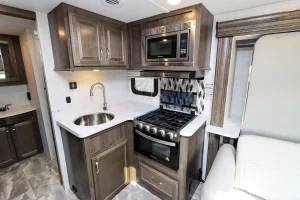 The galley features a three-burner range, oven, and stainless-steel sink.