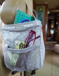 A small tote bag on the arm of the RV's passenger seat keeps reading glasses and small items handy.