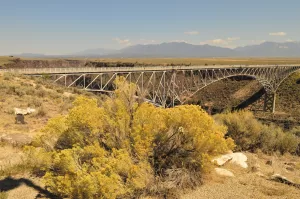 The Rio Grande Gorge Bridge towers over cliffs and the river coursing below it.