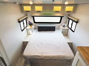 A queen-size bed in the front nestles up to a large panoramic window.
