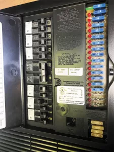 Most RVs will have a single power center like this 50-amp version, with 12-volt-DC fuses in the same panel. The two legs of the 50-amp service feed 50 amps to each side of the panel at 120 volts AC.