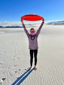 As shown by Elleny, sledding at White Sands National Park in New Mexico makes for great fun. 