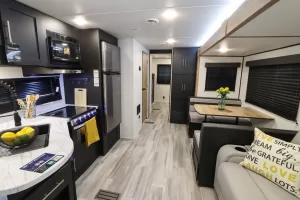 The main slideout holds the dinette and the trifold sofa sleeper; opposite is the galley.