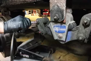 Shackle bolts must be inspected and greased; non-greaseable bolts should be removed and serviced yearly, and neoprene bushings and bolts replaced.